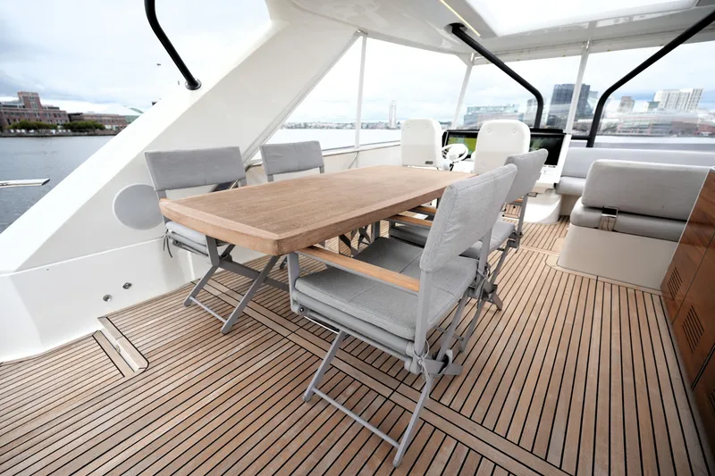 Slide: The Image of Luxurious 2023 Prestige 690 yacht deck with elegant dining area and modern seating. - 35