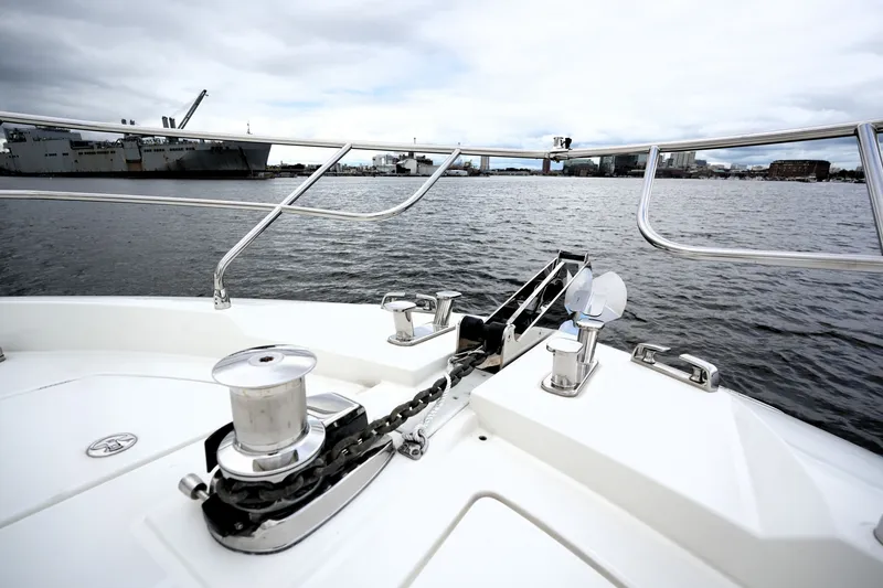 Slide: The Image of Bow view of 2023 Prestige 690 yacht on a calm harbor with cityscape background. - 29