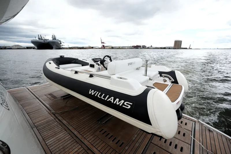 Slide: The Image of 2023 Prestige 690 yacht with Williams SportJet tender on deck, docked at a harbor. - 17