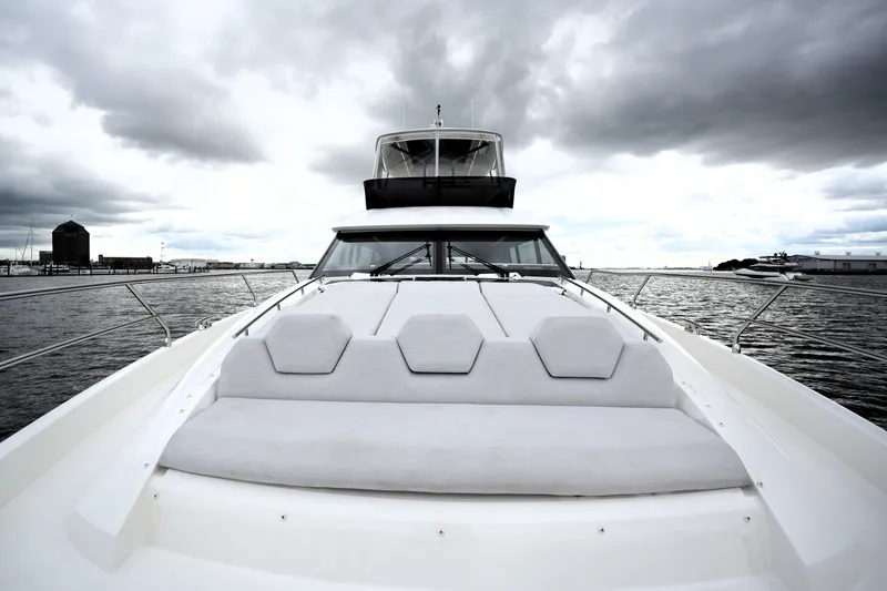 Slide: The Image of 2023 Prestige 690 yacht on water under cloudy sky, showcasing sleek design. - 27