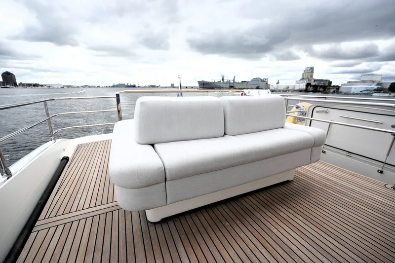 Slide: The Image of Luxurious 2023 Prestige 690 yacht deck with elegant white sofa and scenic waterfront view. - 34