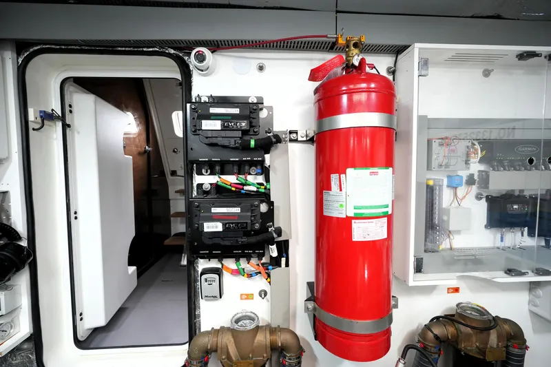 Slide: The Image of Engine room of 2023 Prestige 690 yacht with fire extinguisher and control panels. - 135