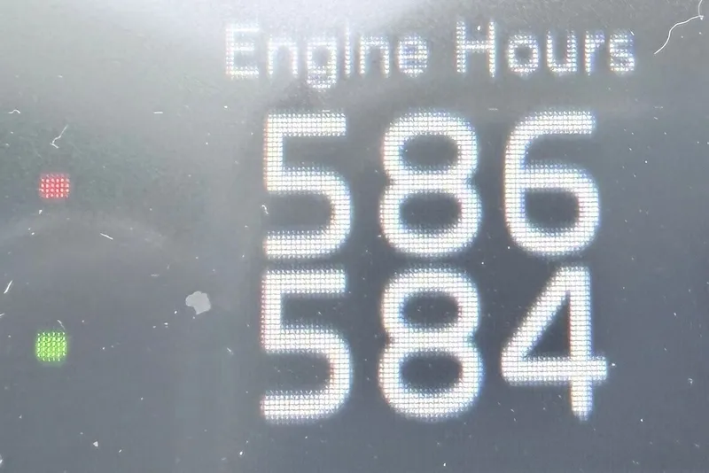 Slide: The Image of Digital display showing engine hours: 586 and 584 on a 2023 Prestige 690. - 84