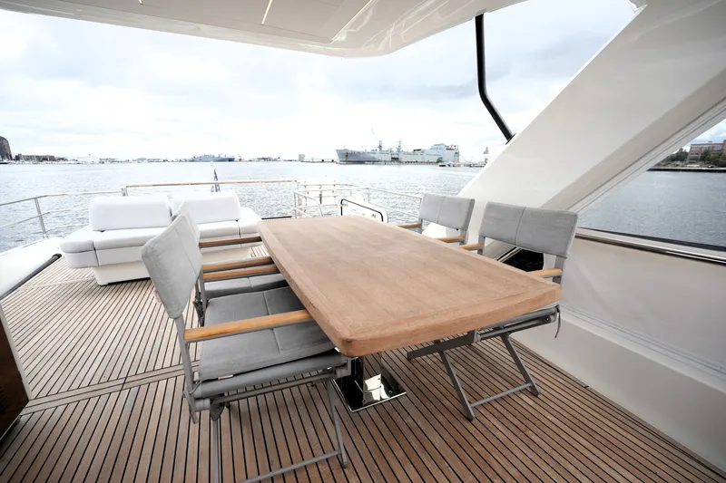 Slide: The Image of Luxurious 2023 Prestige 690 yacht deck with elegant dining area overlooking serene waters. - 36
