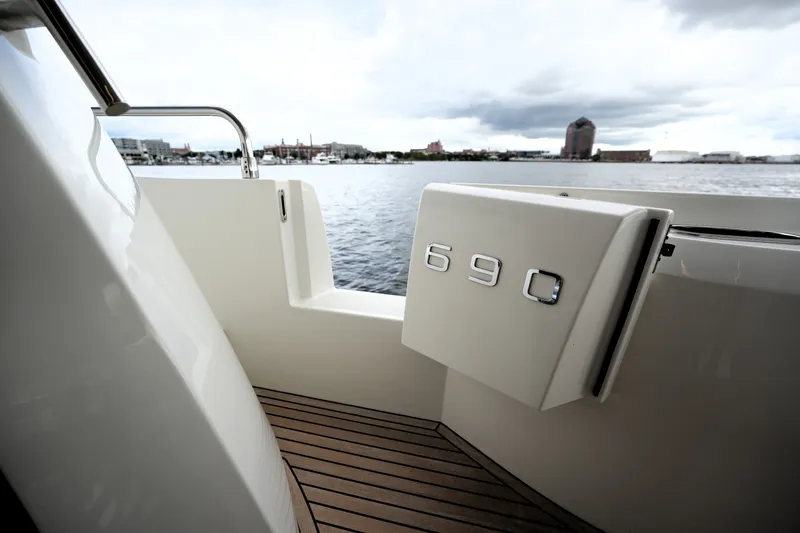 Slide: The Image of Prestige 690 yacht, 2023 model, docked with scenic waterfront view. - 23