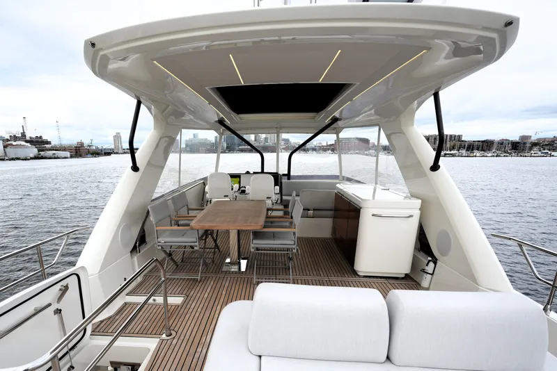 Slide: The Image of Luxurious 2023 Prestige 690 yacht deck with elegant seating and dining area, overlooking serene waters. - 30