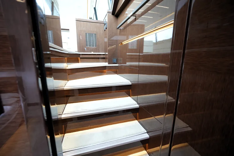 Slide: The Image of Luxurious interior staircase of 2023 Prestige 690 yacht, featuring elegant wood paneling and ambient lighting. - 86