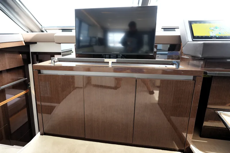 Slide: The Image of Luxurious interior of 2023 Prestige 690 yacht featuring sleek cabinetry and modern TV setup. - 73