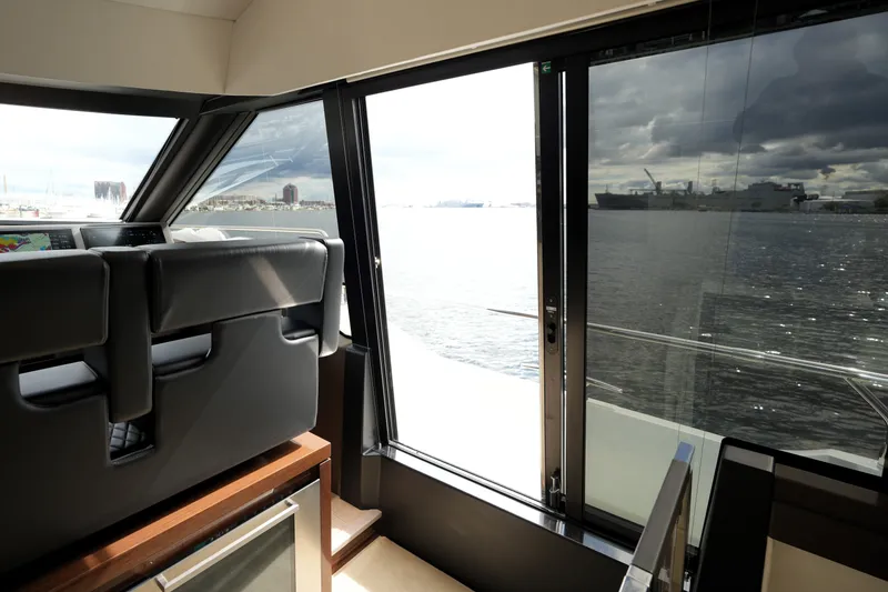 Slide: The Image of Interior view of 2023 Prestige 690 yacht, showcasing sleek design and waterfront scenery. - 75