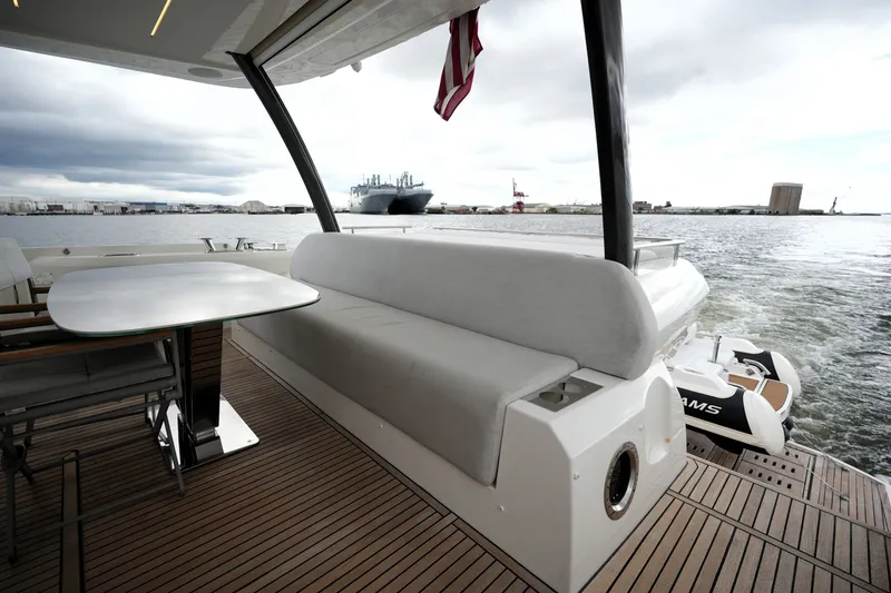 Slide: The Image of Luxury yacht Prestige 690 deck with seating and table, overlooking a harbor view. - 18