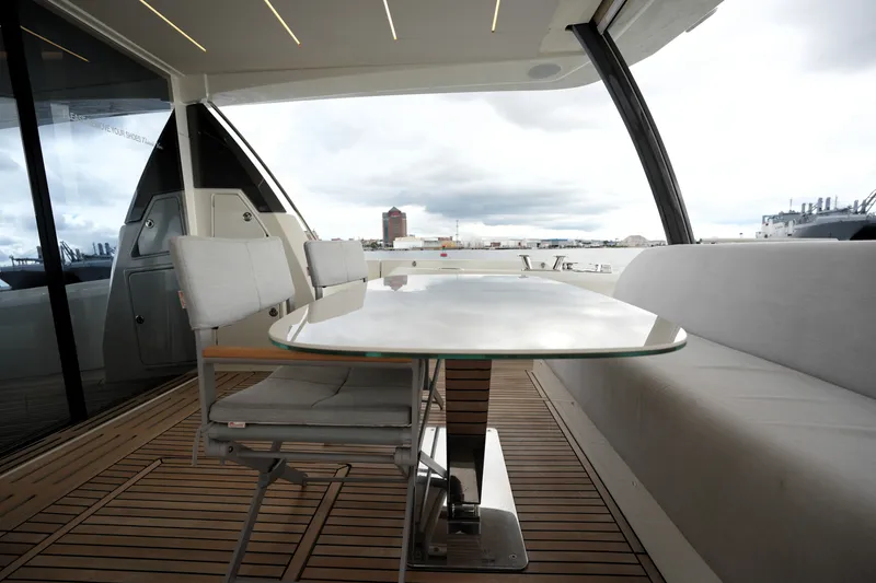 Slide: The Image of Luxurious 2023 Prestige 690 yacht deck with elegant seating and glass table. - 21