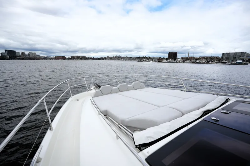 Slide: The Image of Luxurious 2023 Prestige 690 yacht with spacious deck, overlooking serene waterfront cityscape. - 26