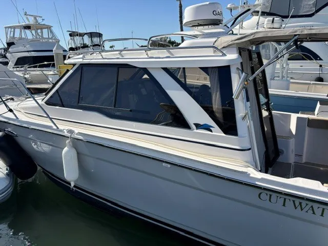 Slide: The Image of A modern 2026 Cutwater C-248 Coupe docked at a marina. It features sleek design and large windows. - 14