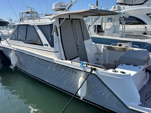 Slide: The Image of A modern 2026 Cutwater C-248 Coupe docked in a marina, surrounded by other boats. - 28