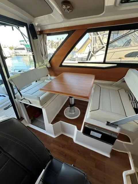 Slide: The Image of Interior of a 2026 Cutwater C-248 Coupe with a wooden table and white seating. - 50