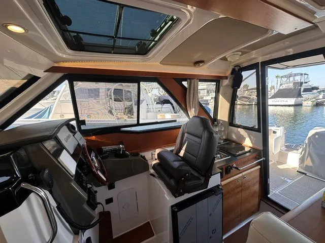 Slide: The Image of Interior view of a modern boat cabin with steering wheel, seat, and large windows. - 42