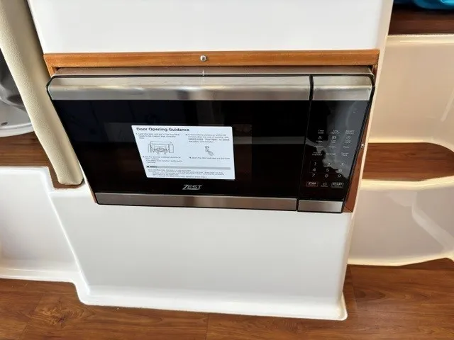 Slide: The Image of A microwave is built into a white kitchenette with wood accents and an instruction guide. - 46