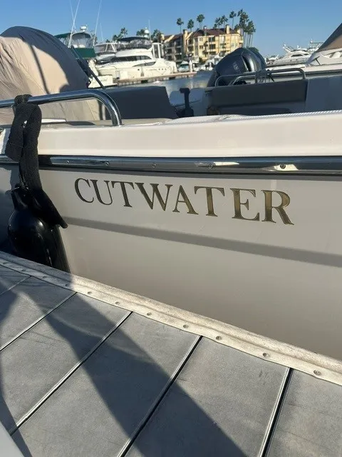 Slide: The Image of A 2026 Cutwater C-248 Coupe docked in a marina. The name is visible on the side. - 7