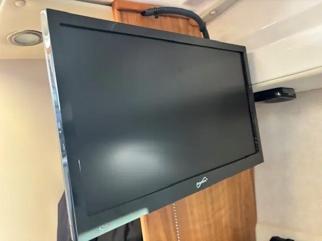 Slide: The Image of A flat-screen TV is mounted on a wooden wall inside a boat. - 47