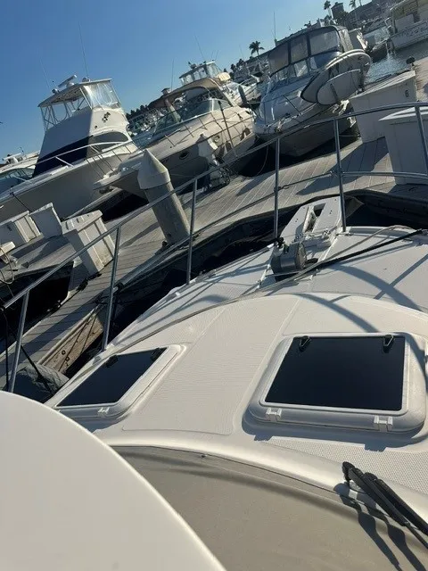 Slide: The Image of A 2026 Cutwater C-248 Coupe docked in a busy marina, surrounded by other boats. - 5