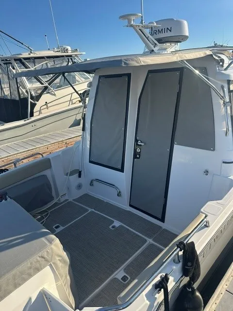 Slide: The Image of The image shows the stern of a 2026 Cutwater C-248 Coupe boat with gray doors and a Garmin radar. - 25