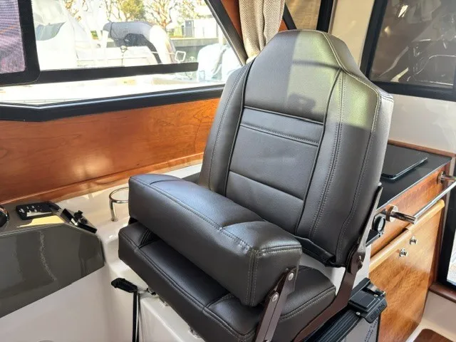 Slide: The Image of A luxurious black leather captain's chair in a modern boat cockpit with wood accents. - 38