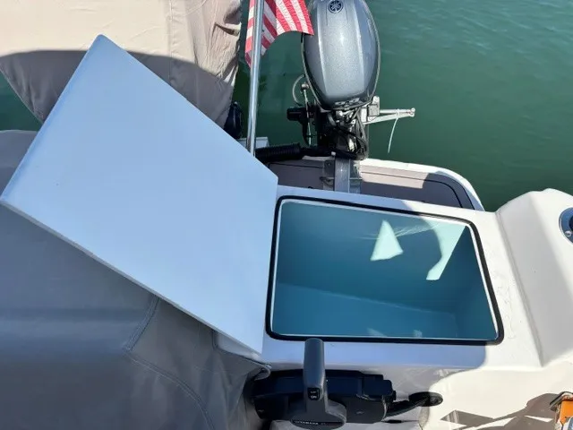 Slide: The Image of An open storage compartment on a Cutwater C-248 Coupe boat, with an outboard motor in the background. - 19