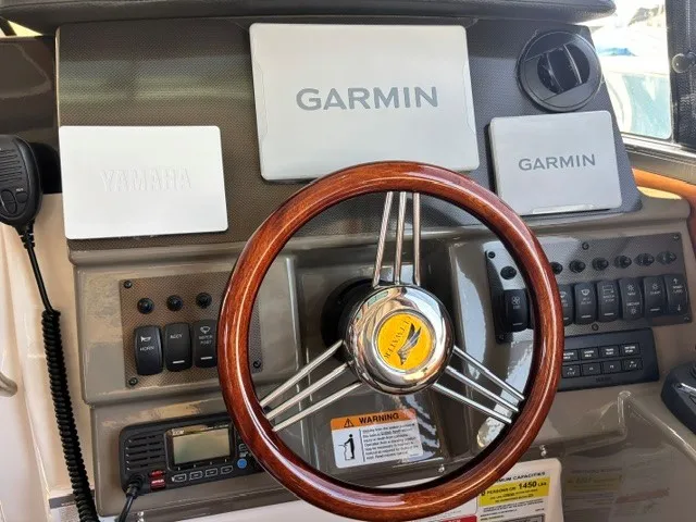 Slide: The Image of The image shows the helm of a Cutwater C-248 Coupe with a wooden steering wheel and Garmin electronics. - 37