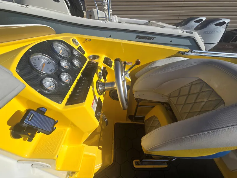 Slide: The Image of The cockpit of a 2007 Baja 26 Outlaw with a yellow dashboard and white seats. - 11