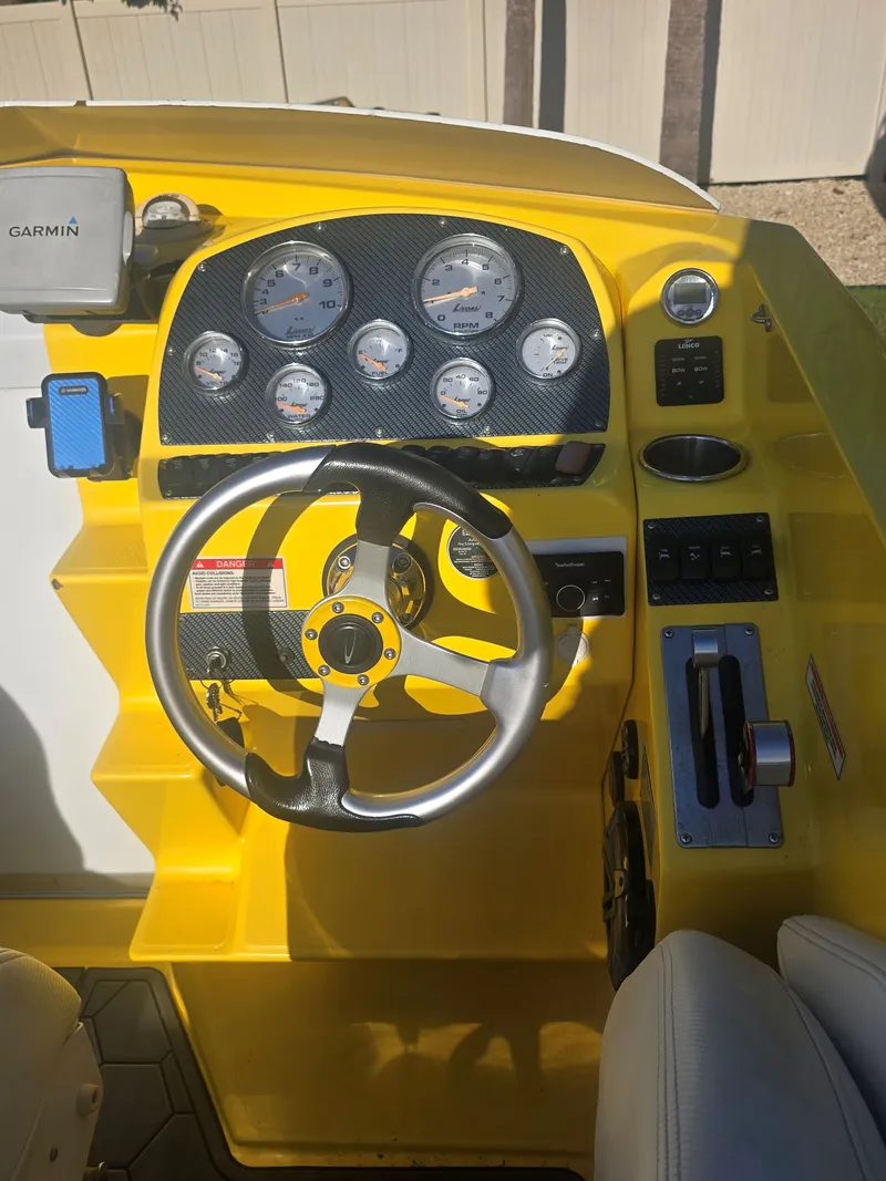Slide: The Image of The image shows the yellow cockpit of a 2007 Baja 26 Outlaw with a steering wheel and gauges. - 10
