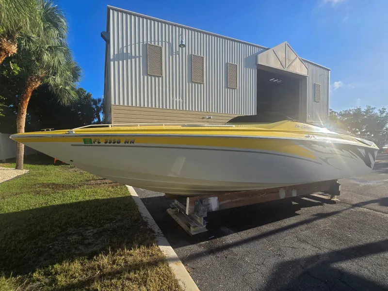 Slide: The Image of A yellow and white 2007 Baja 26 Outlaw boat on a trailer in front of a building. - 4