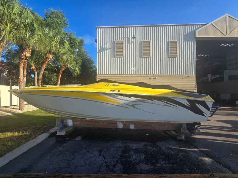 Slide: The Image of A yellow 2007 Baja 26 Outlaw boat sits on a trailer in front of a building. - 1