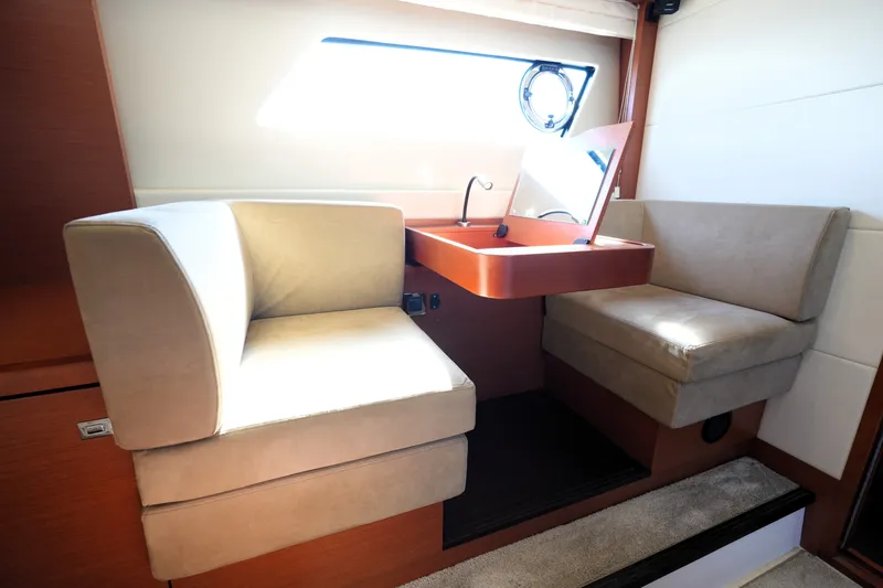 Slide: The Image of Luxurious seating area inside a 2016 Prestige 550 yacht, featuring plush beige cushions. - 81