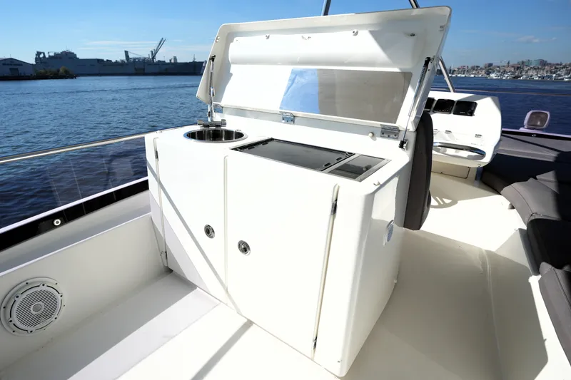 Slide: The Image of Prestige 550 yacht's outdoor kitchenette with sink, overlooking a scenic waterfront, 2016 model. - 39
