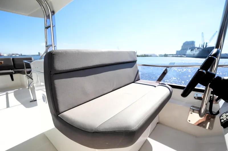 Slide: The Image of 2016 Prestige 550 yacht helm seat with waterfront view, showcasing luxury and comfort. - 32