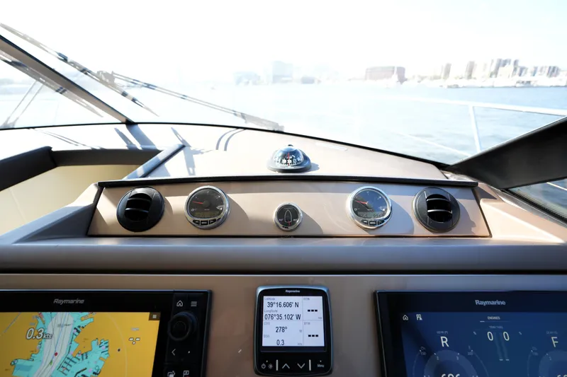 Slide: The Image of Cockpit view of 2016 Prestige 550 yacht with navigation instruments and cityscape background. - 69