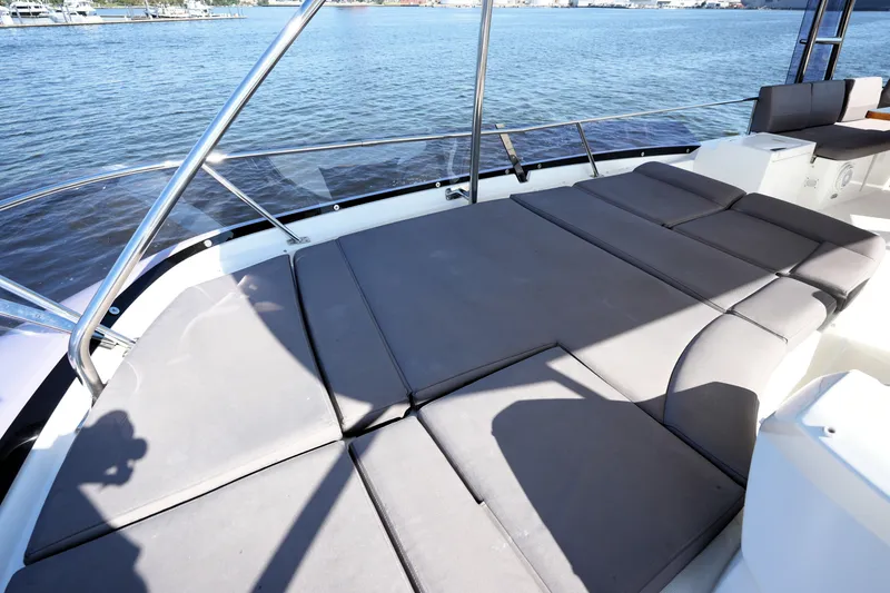 Slide: The Image of 2016 Prestige 550 yacht with spacious sunbathing deck overlooking serene waters. - 30