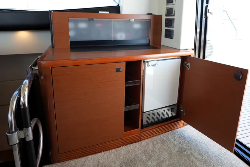 Slide: The Image of Luxurious interior of 2016 Prestige 550 yacht featuring a wooden cabinet with open fridge. - 44