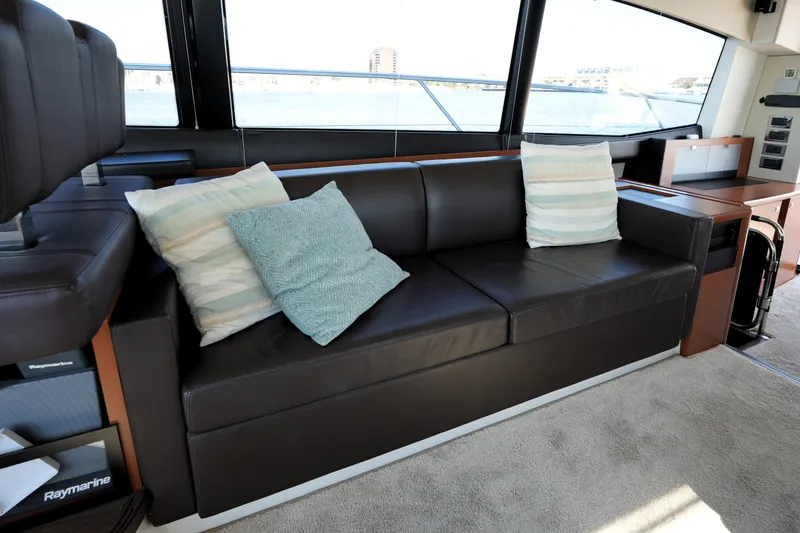 Slide: The Image of Luxurious interior of a 2016 Prestige 550 yacht with a sleek leather sofa and cushions. - 56