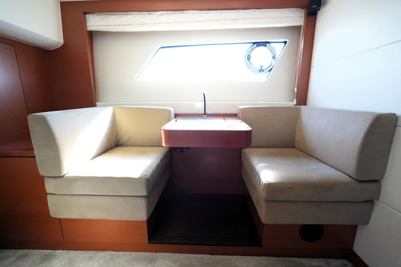 Slide: The Image of Luxurious seating area in a 2016 Prestige 550 yacht, featuring plush cushions and a sleek table. - 80