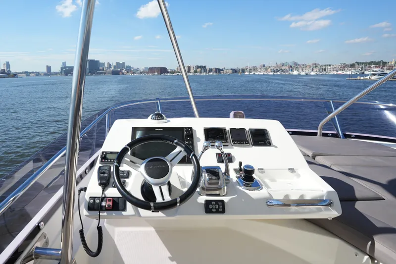 Slide: The Image of Cockpit view of 2016 Prestige 550 yacht with city skyline in background. - 33