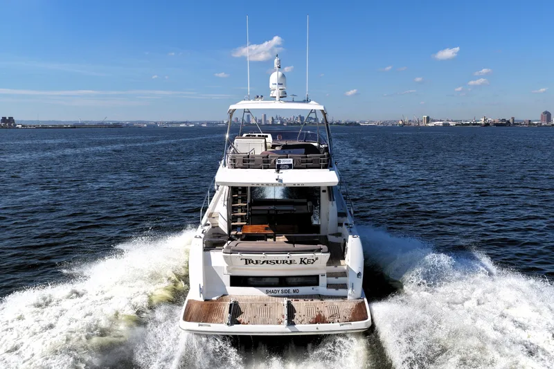 Slide: The Image of 2016 Prestige 550 yacht cruising on open water under a clear blue sky. - 9