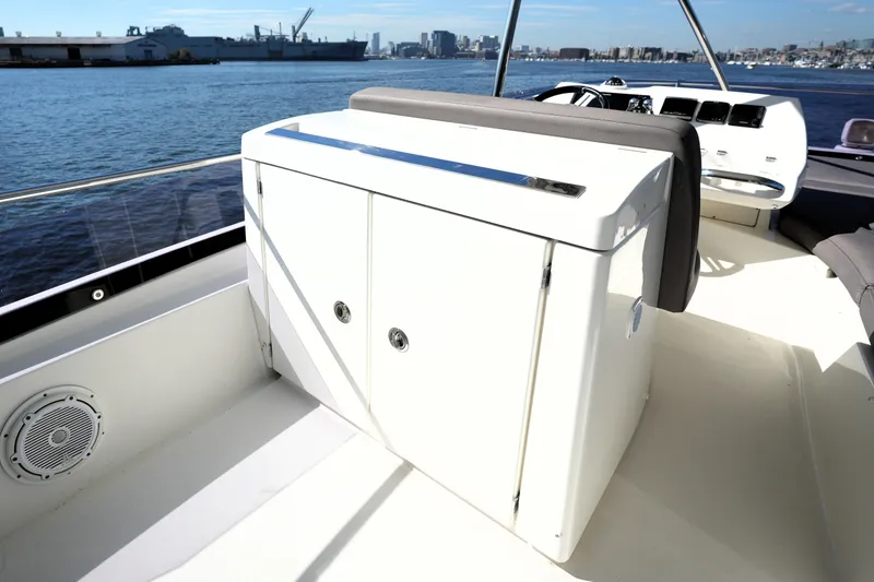 Slide: The Image of 2016 Prestige 550 yacht deck with seating and storage, overlooking a harbor view. - 38
