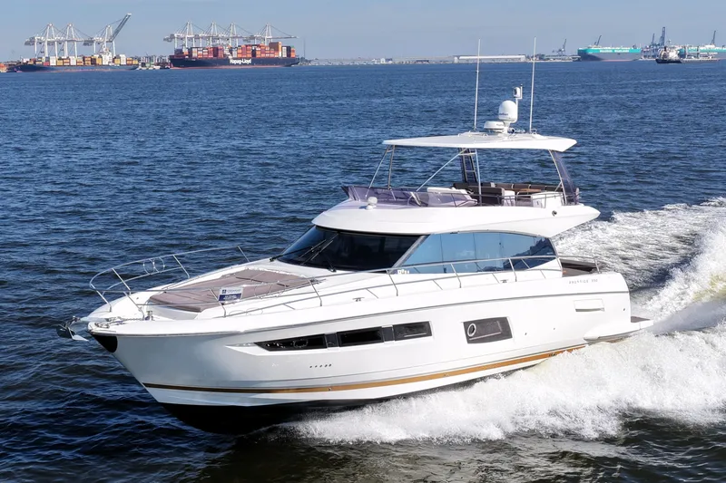 Slide: The Image of Luxury 2016 Prestige 550 yacht cruising near a busy port. - 12
