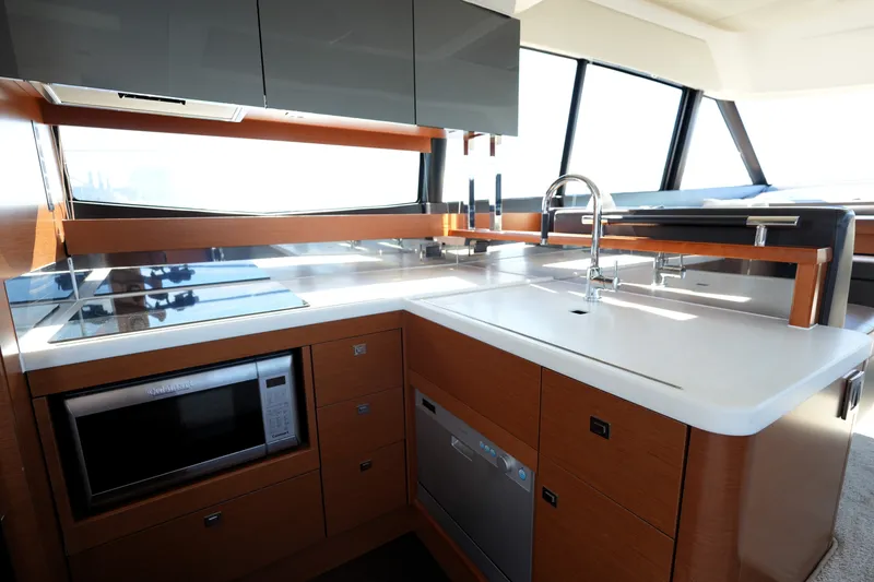 Slide: The Image of Modern kitchen interior on a 2016 Prestige 550 yacht, featuring sleek appliances and ample counter space. - 49