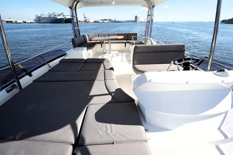 Slide: The Image of Luxurious 2016 Prestige 550 yacht deck with seating and scenic waterfront view. - 26