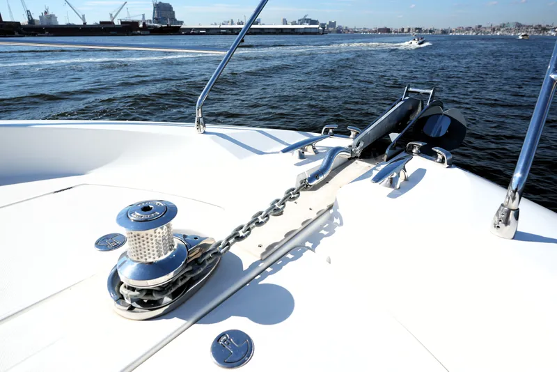 Slide: The Image of 2016 Prestige 550 yacht anchor and chain on deck, with ocean and cityscape background. - 24