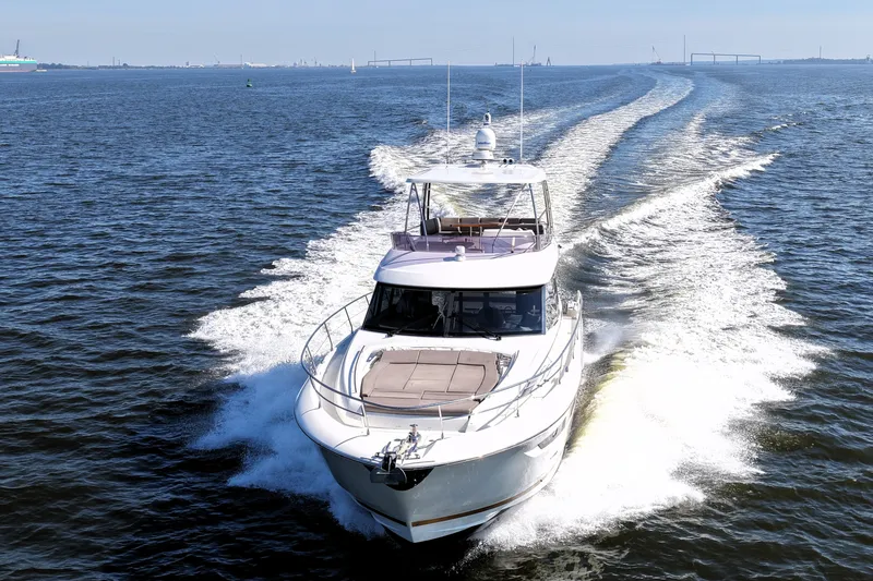 Slide: The Image of Luxury 2016 Prestige 550 yacht cruising on open water, leaving a wake behind. - 13