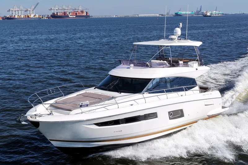 Slide: The Image of Luxury 2016 Prestige 550 yacht cruising on open water near shipping port. - 10