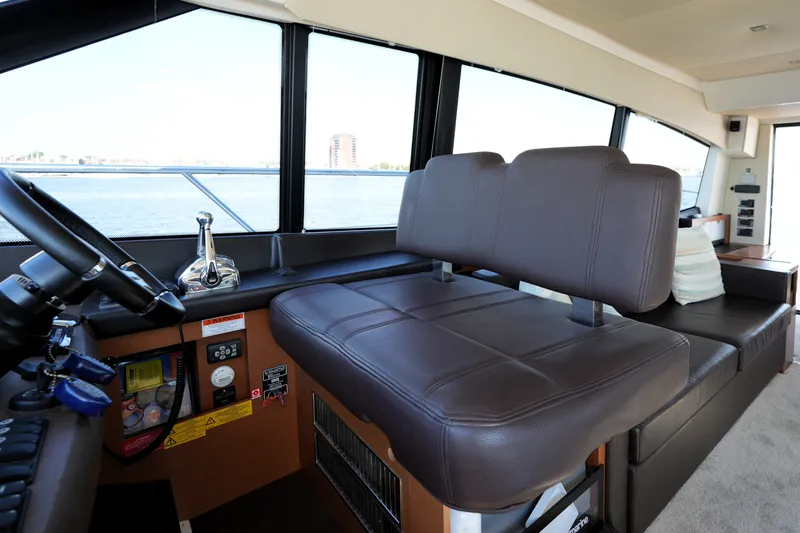 Slide: The Image of Interior of a 2016 Prestige 550 yacht, featuring a leather helm seat and control panel. - 64